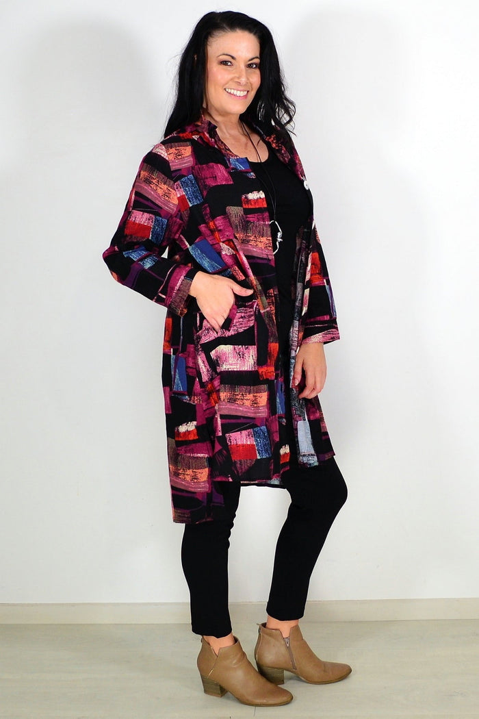 Abstract pink tunic shirt by Wishstone, featuring a flowy design and long sleeves, displayed on a hanger.