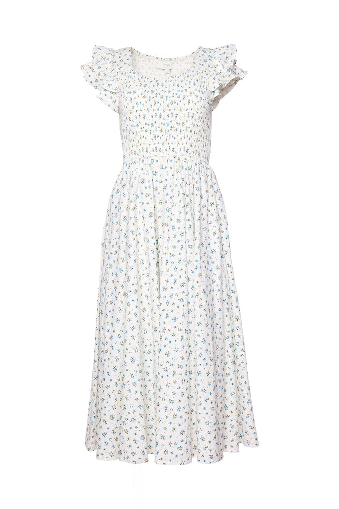 The Hattie Dress in Madeline Blue by Ivy City Co is a white, ankle-length cotton midi dress with a smocked bodice, short ruffled sleeves, and a delicate blue and green floral print. Its flowy skirt highlights the feminine, summery style.