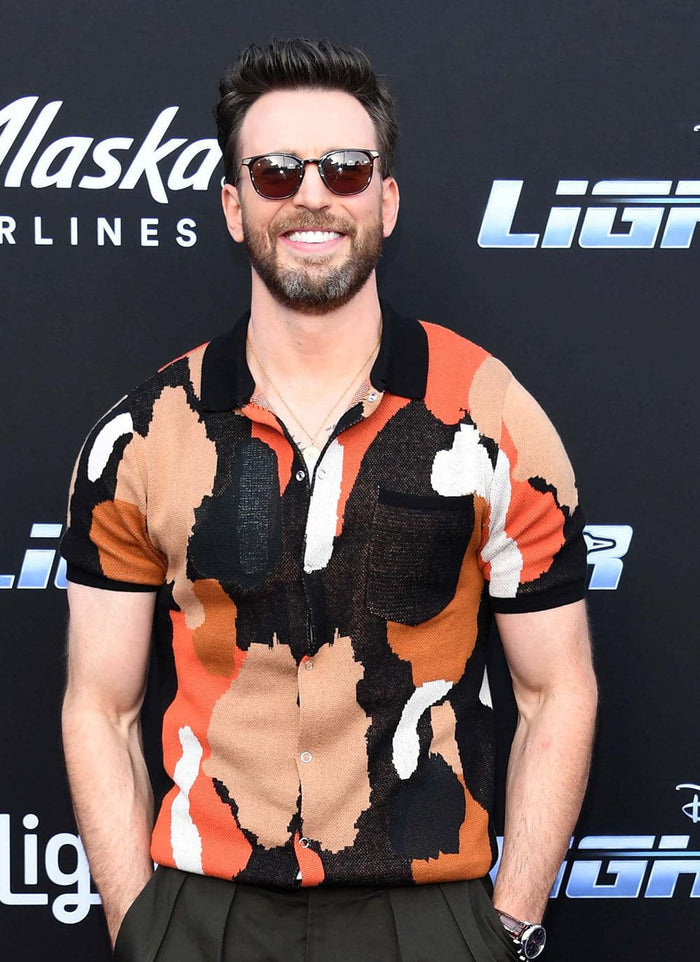 Chris Evans wearing the Percival Impressionist Jacquard Shirt, a black knitted shirt with an orange, cream and brown pattern.