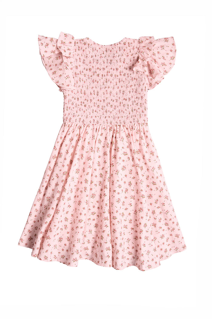 The Ivy City Co Mini Hattie Dress in Madeline Pink is a light pink girls' cotton dress with a small floral print, ruffled short sleeves, smocked bodice, and softly flared skirt for a flowy look. Displayed on a white background.