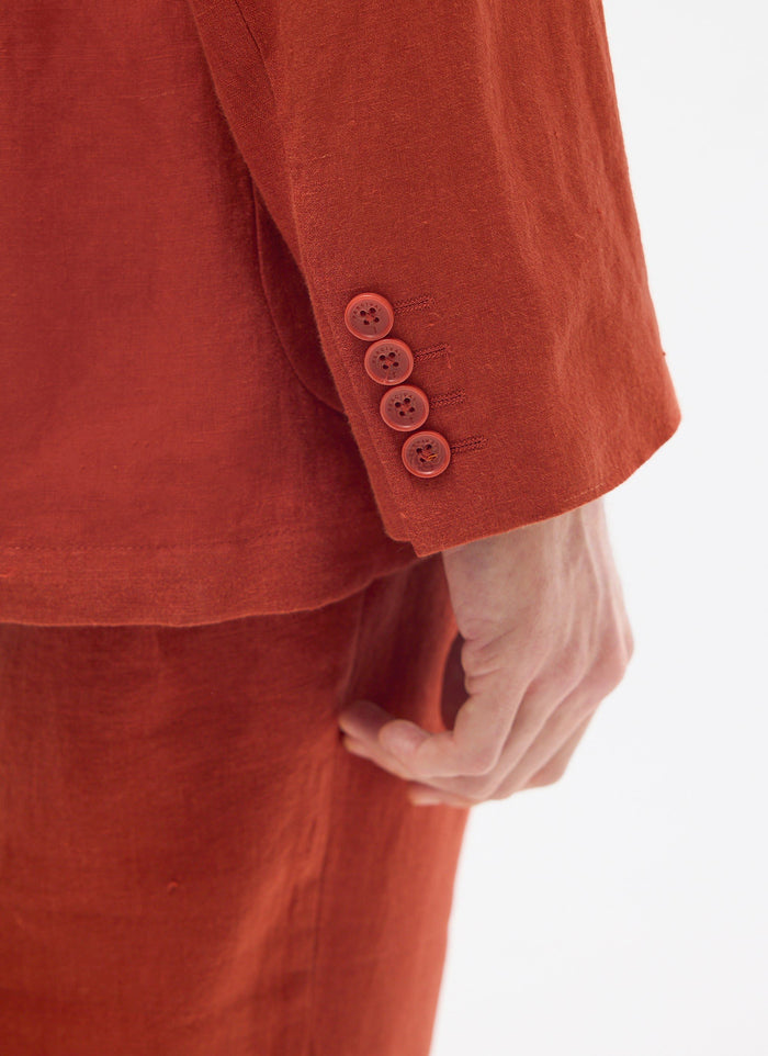 close up of rust linen blazer cuff with four Percival branded buttons