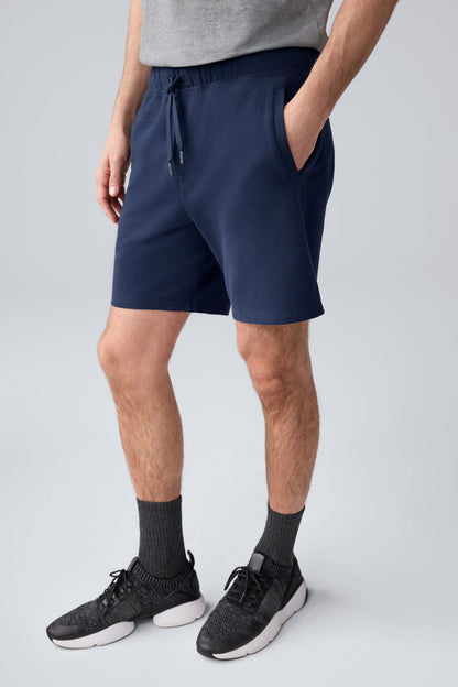 Side view of a man wearing ACE Sweatshort 7” in Total Eclipse