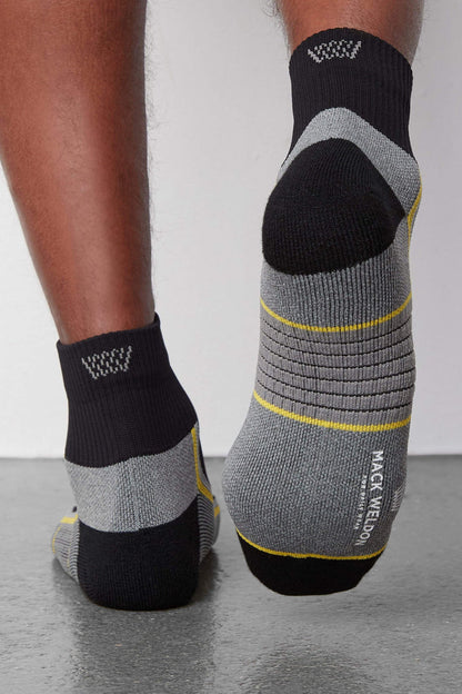 Back view of a man wearing AIRKNITx High Ankle Sock in True Black /Taxi