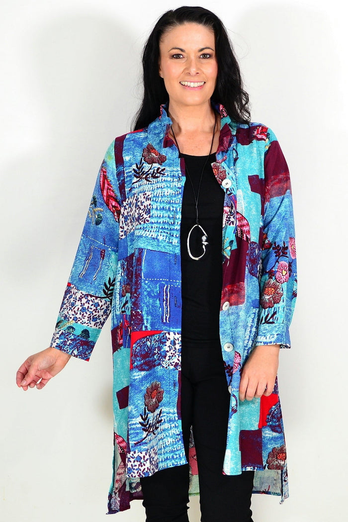 Abstract blue wishstone tunic shirt with flowing fabric and relaxed fit, displayed on a hanger.