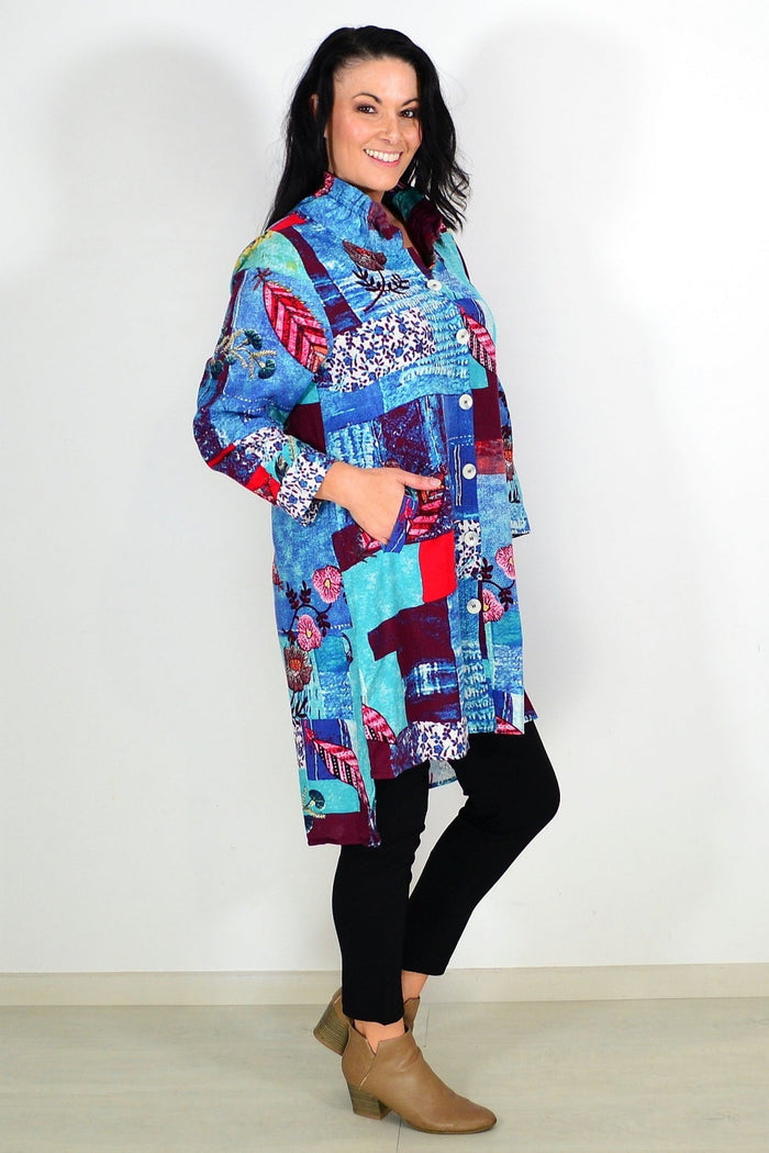 Abstract blue wishstone tunic shirt with a flowy fit, shown on a hanger against a neutral background.