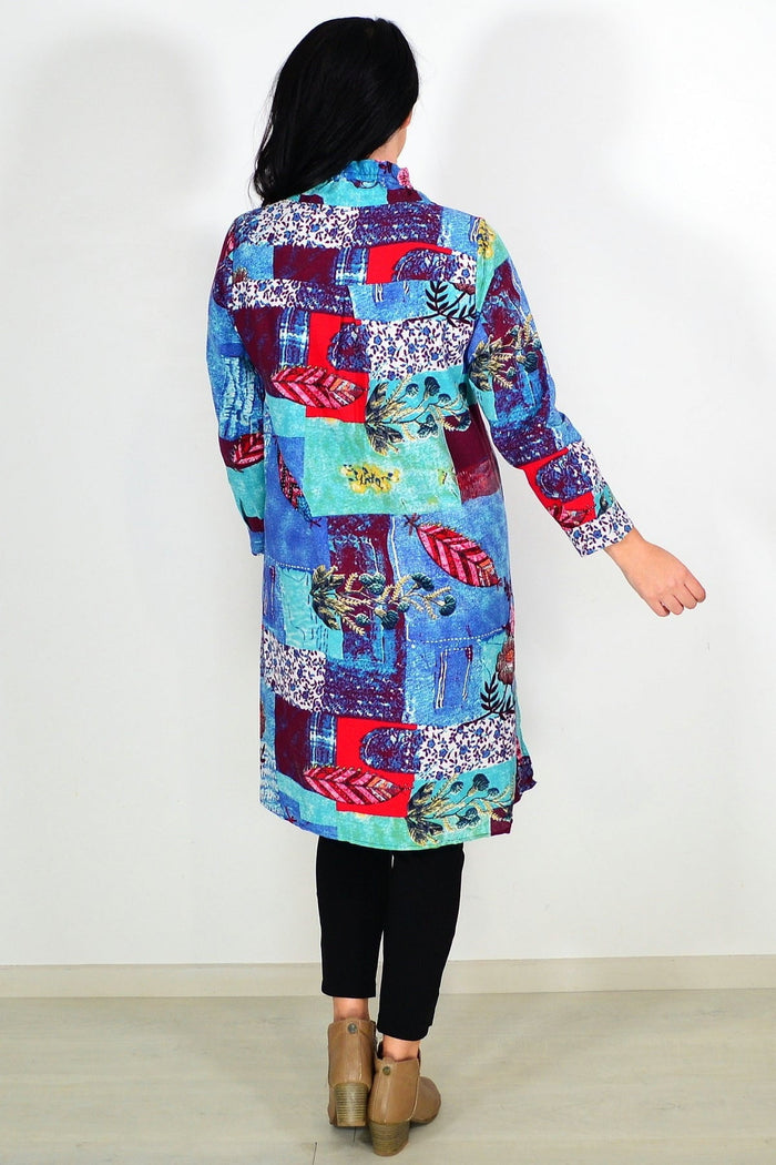 Abstract blue wishstone tunic shirt displayed on a hanger with flowing fabric and casual style.