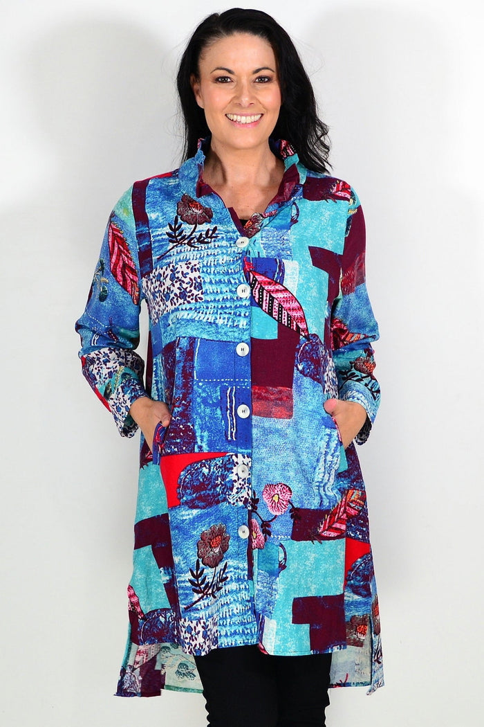 Abstract blue wishstone tunic shirt displayed on a hanger, showcasing its flowy fabric and relaxed fit.