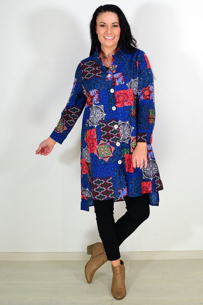 Abstract navy wishstone tunic shirt hanging on a wooden hanger, showcasing its relaxed, flowing design and lightweight fabric.
