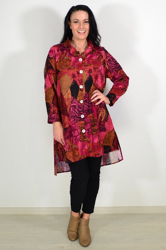 Abstract pink and mustard wishstone tunic shirt with long sleeves and relaxed fit, displayed on a hanger.