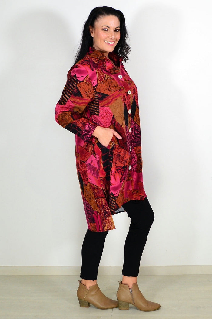 Abstract pink and mustard tunic shirt by Wishstone, featuring loose fit and stylish design, displayed on a hanger.