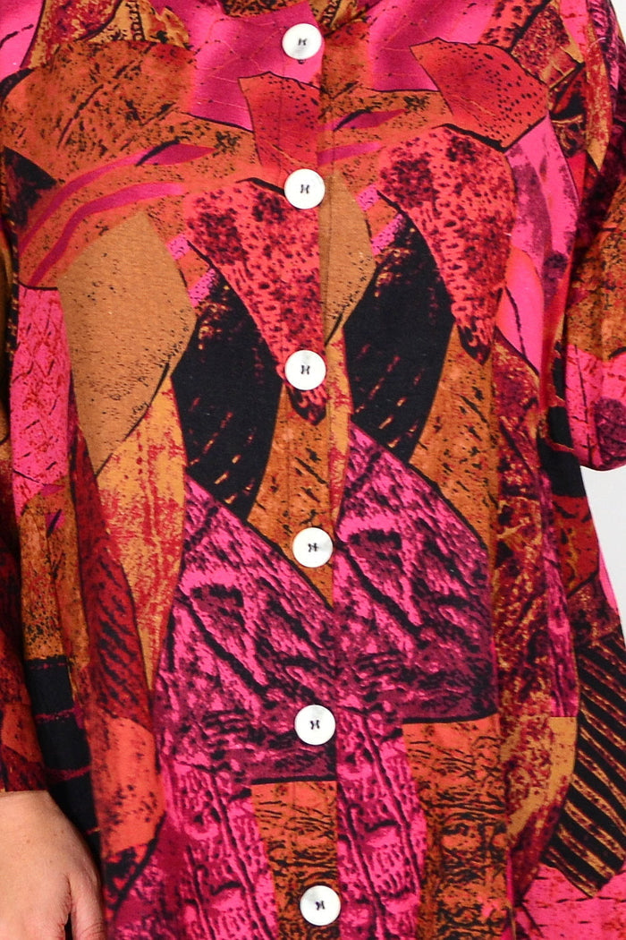 Pink mustard abstract tunic shirt by Wishstone, featuring a stylish design and relaxed fit, displayed on a hanger.