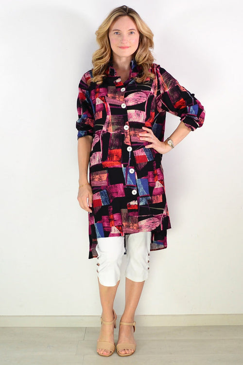 Abstract pink wishstone tunic shirt with long sleeves and relaxed fit, shown on a hanger against a neutral background.