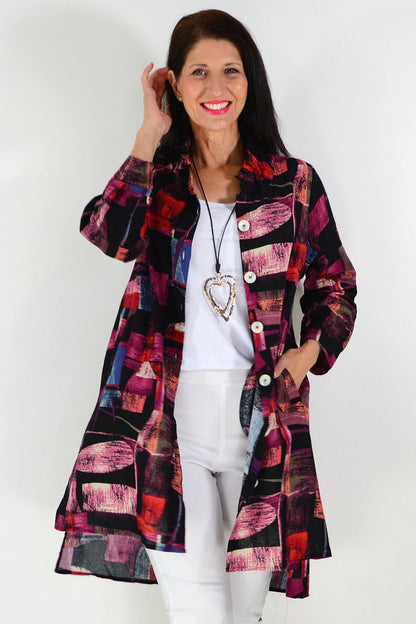 Pink abstract print tunic shirt by Wishstone, lightweight and flowy, displayed on a hanger with a relaxed fit.