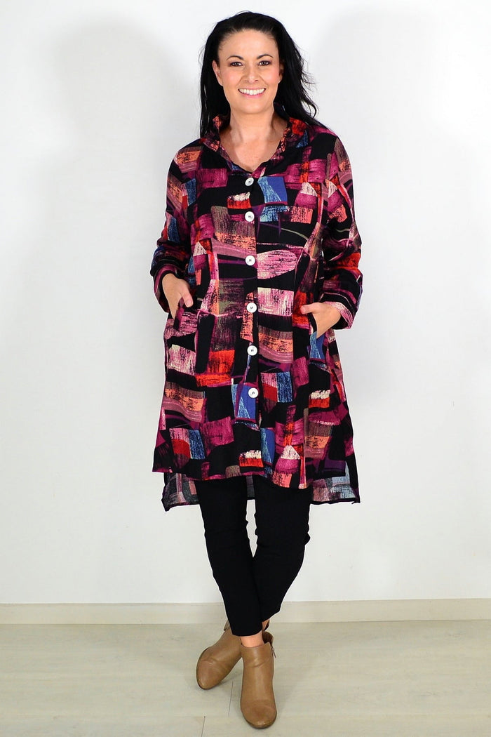 Abstract pink wishstone tunic shirt with flowing fabric and relaxed fit, displayed on a hanger.