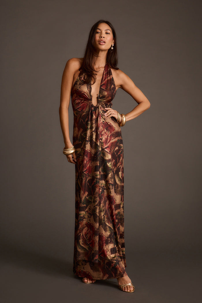 Metallic floral maxi dress with a halter neckline and plunging keyhole front, styled with gold cuff bracelets.