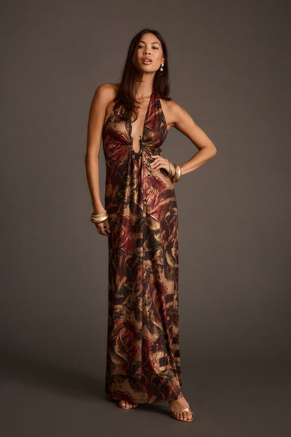 Metallic floral maxi dress with a halter neckline and plunging keyhole front, styled with gold cuff bracelets.