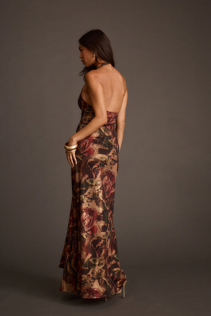 Backless halter maxi dress with a metallic floral print and floor-length hem.