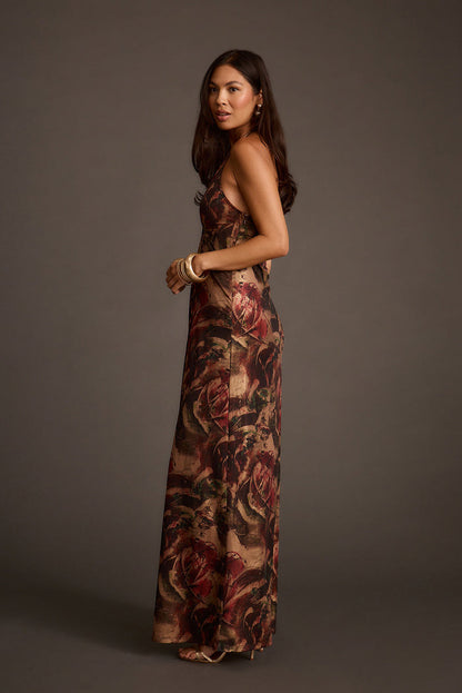 Side view of a metallic floral maxi dress with a floor-length silhouette and side slit.
