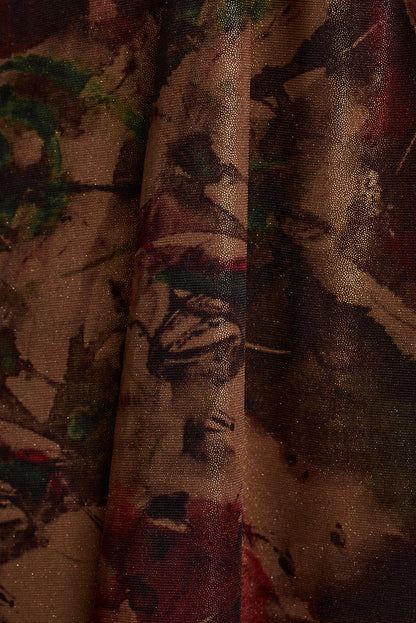 Close-up of shimmering metallic floral print fabric in burgundy, bronze, and deep green tones.