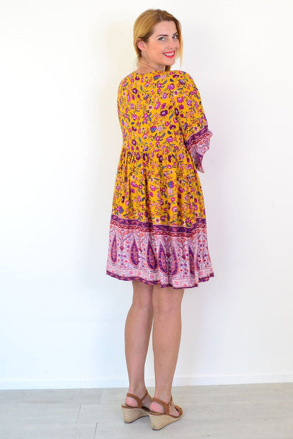 Dream Amelia Mustard Bohemian Tunic Dress with flowing fabric and boho-inspired design, displayed on a hanger.