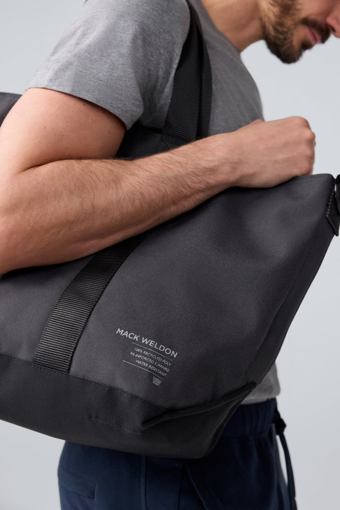 Side view of man carrying Atlas Tote over his shoulder