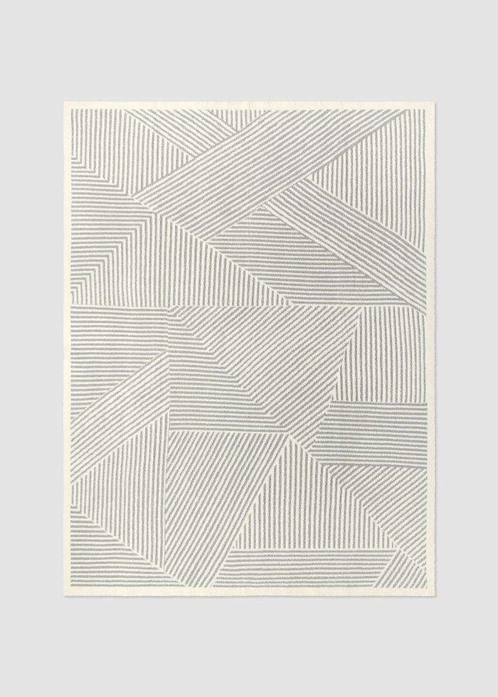 Grey and white striped blanket on a grey background