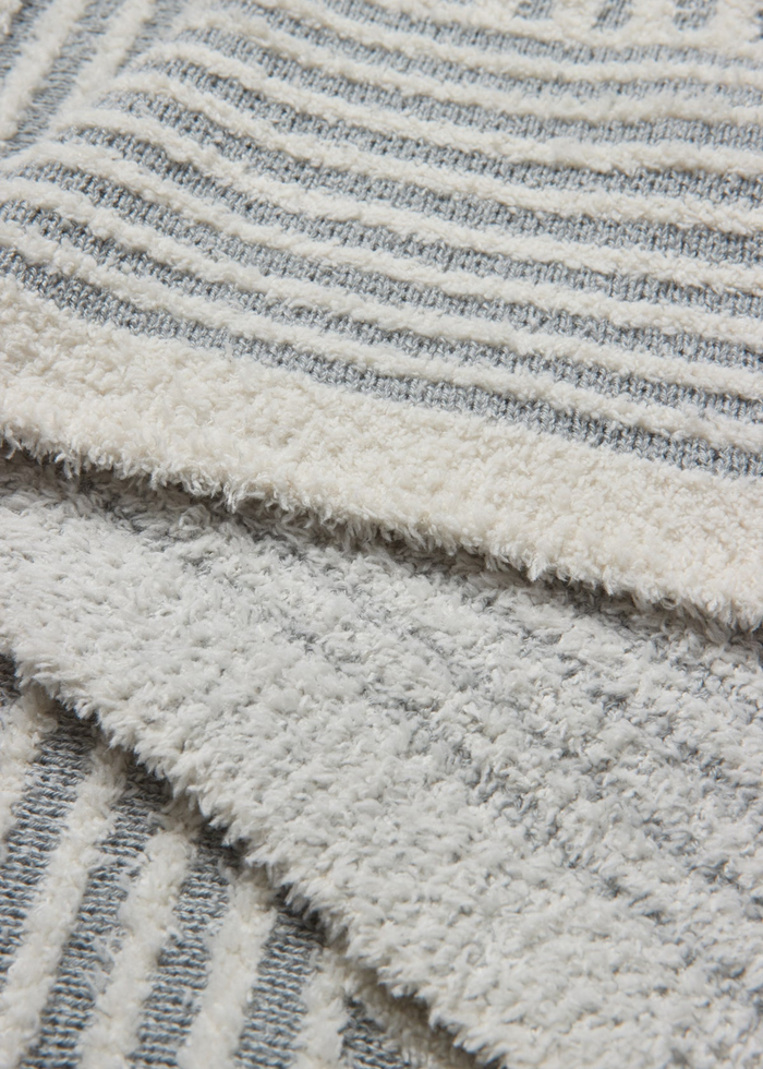 Close up of a grey and white stripe blanket