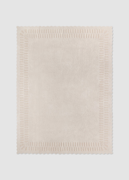 Cream blanket laying on a grey background