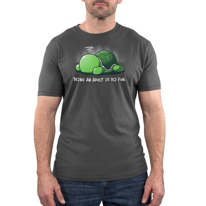Premium Cotton T-shirt_TeeTurtle Being an Adult is So Fun Charcoal Gray t-shirt featuring a cartoon turtle lying face down with a stressed expression, accompanied by the text "Being an adult is so fun."