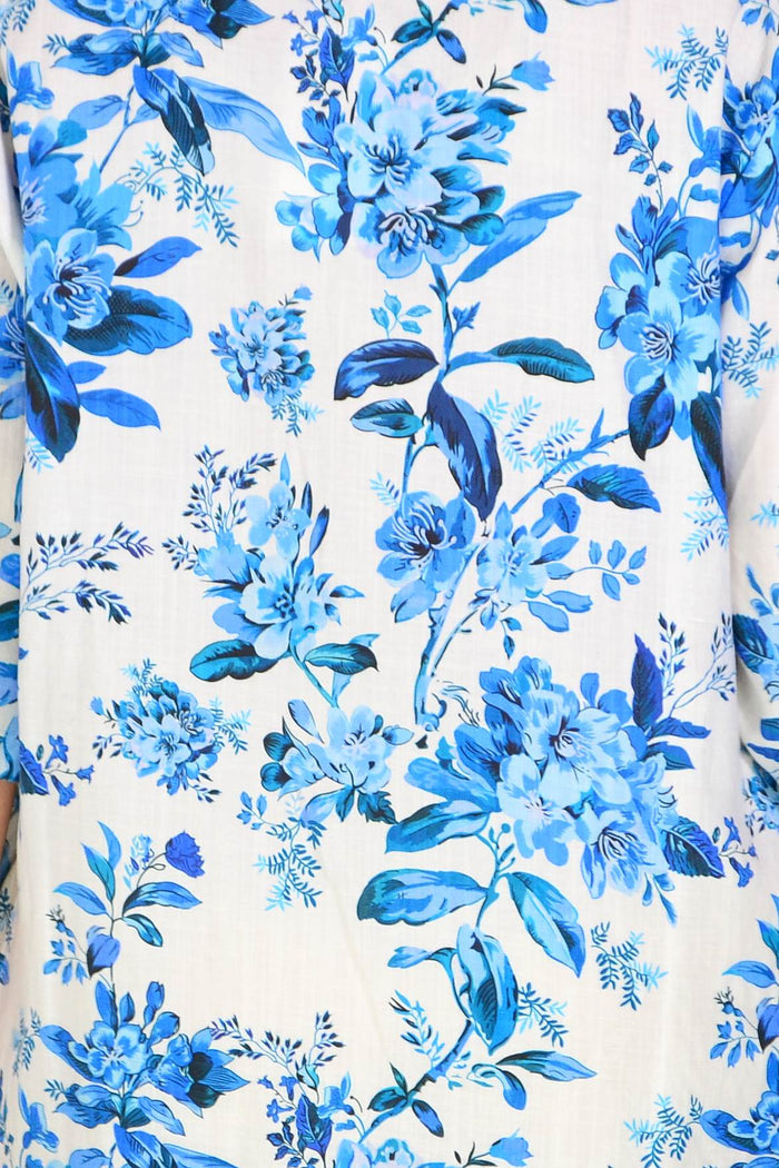 Blue floral linen blend tunic by La Mode with a relaxed fit, featuring a V-neck and long sleeves, displayed on a hanger.