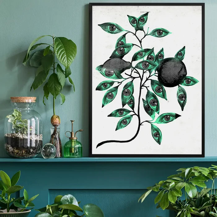 Striking Botanical Eyes print with green leaves and black fruit-like shapes, framed on a teal shelf.