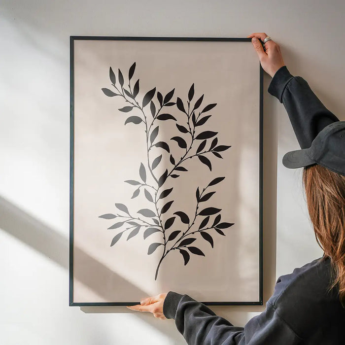 Branch Silhouette Print 1 being hung on a wall in a black frame