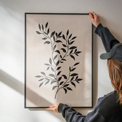 Branch Silhouette Print 1 being hung on a wall in a black frame