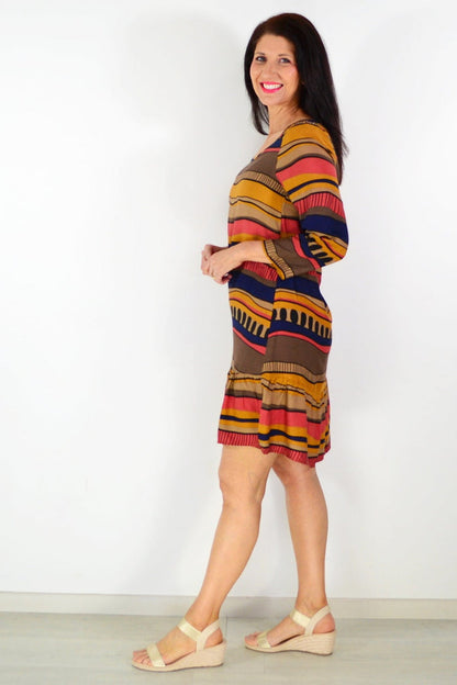 Brown Swirls Tunic Dress by Hourglass, featuring a flowing fabric with swirling pattern, displayed on a hanger.
