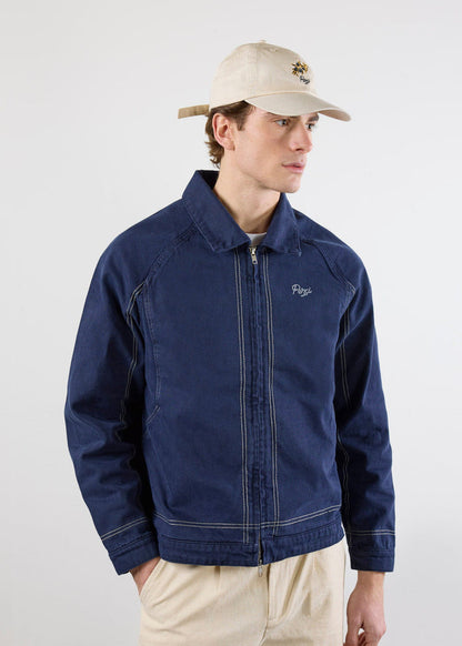 A model wears the Percival Calabria Harrington Jacket in navy cotton, featuring a zip-up front and contrast stitch details.