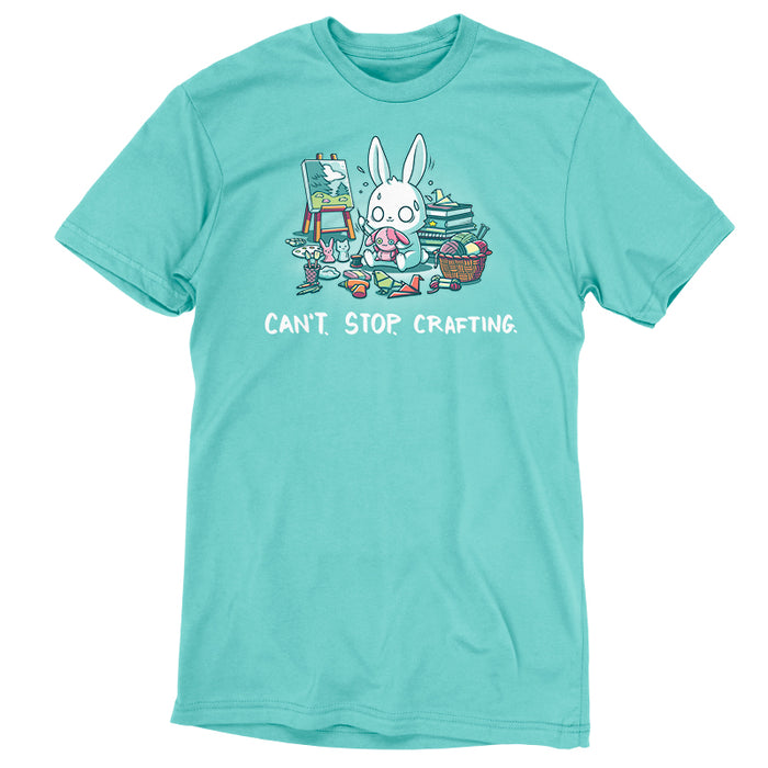 Premium Cotton T-shirt_TeeTurtle Can't. Stop. Crafting. Caribbean blue t-shirt featuring an illustration of a white rabbit with large, expressive eyes, and sweat droplets coming from its head sewing a small pink bunny surrounded by crafting materials like balls of yarn in a woven basket, paint pallets and brushes,  origami birds and other shapes, sewing thread, small stuffed animals, books stacked high, craft knives, and other crafting supplies, with the text "CAN'T. STOP. CRAFTING." at the bott