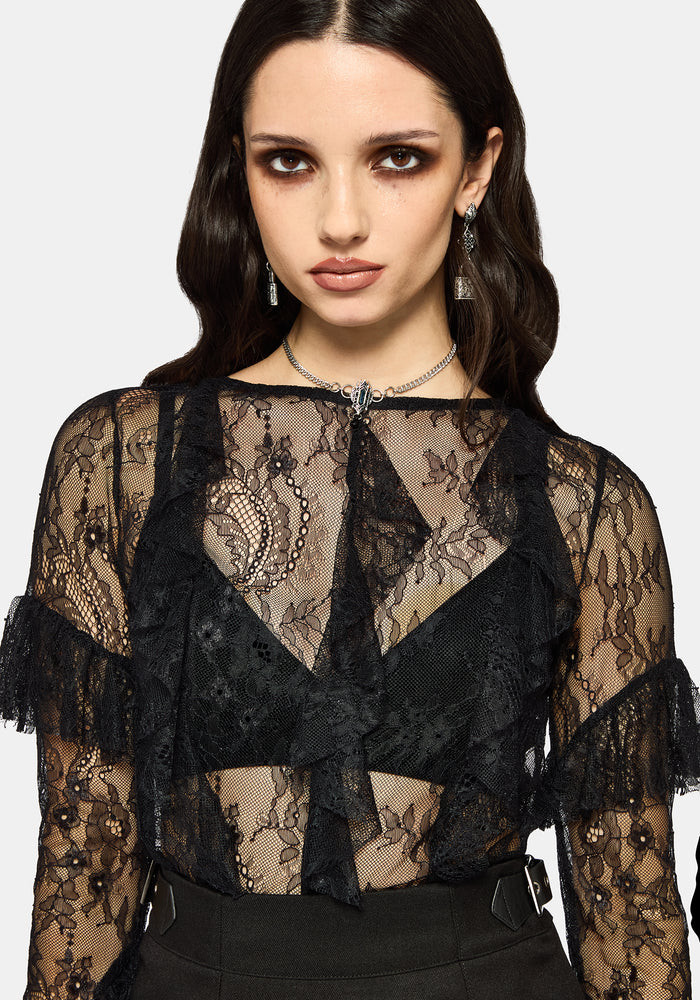 Woman wearing a black lace top against a white studio background