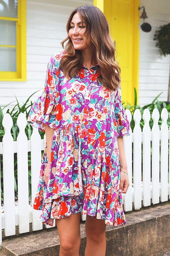 Colorful bohemian shirt dress by Dream, featuring vibrant patterns and a relaxed tunic style, displayed on a clipboard.