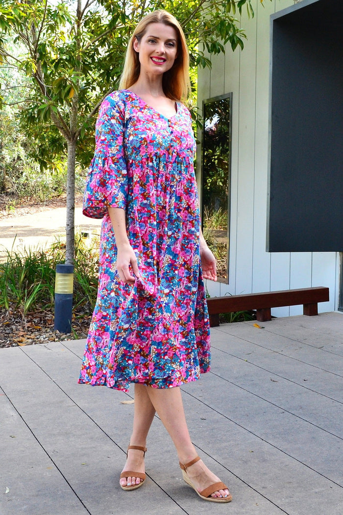 Colorful floral garden tunic dress by Hourglass, featuring vibrant floral patterns and a relaxed fit, displayed on a hanger.