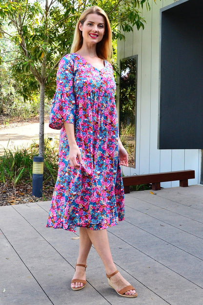 Colorful floral garden tunic dress by Hourglass, featuring vibrant floral patterns and a relaxed fit, displayed on a hanger.