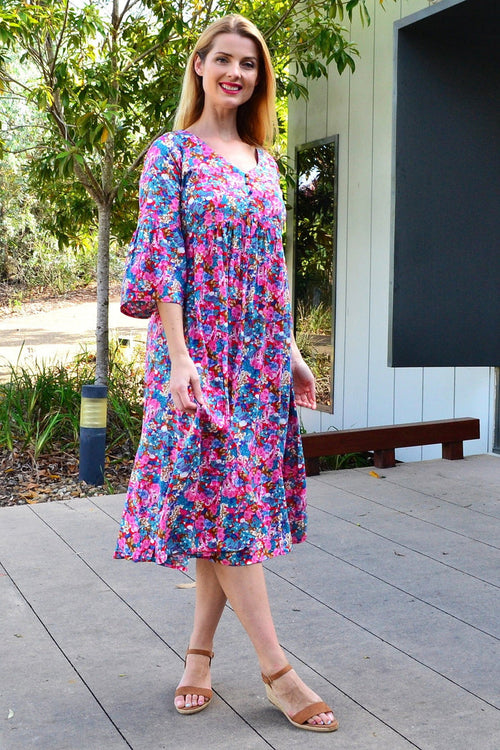 Colorful floral garden tunic dress by Hourglass, featuring vibrant floral patterns and a relaxed fit, displayed on a hanger.