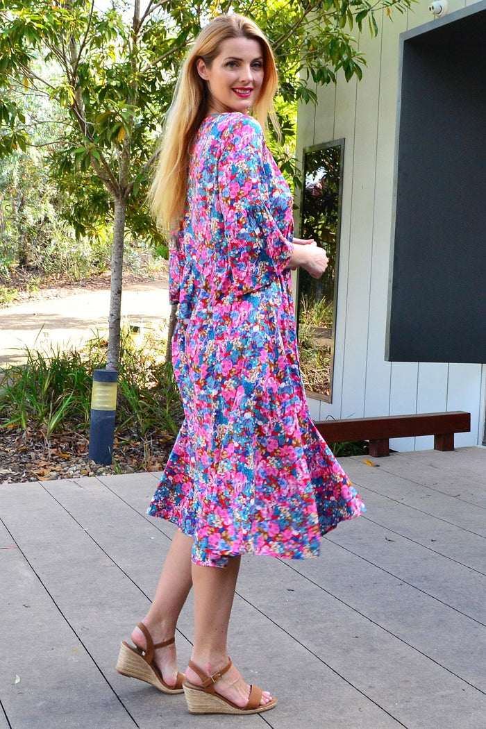 Colorful floral garden tunic dress by Hourglass, featuring vibrant flower patterns and a comfortable fit, shown on a model.