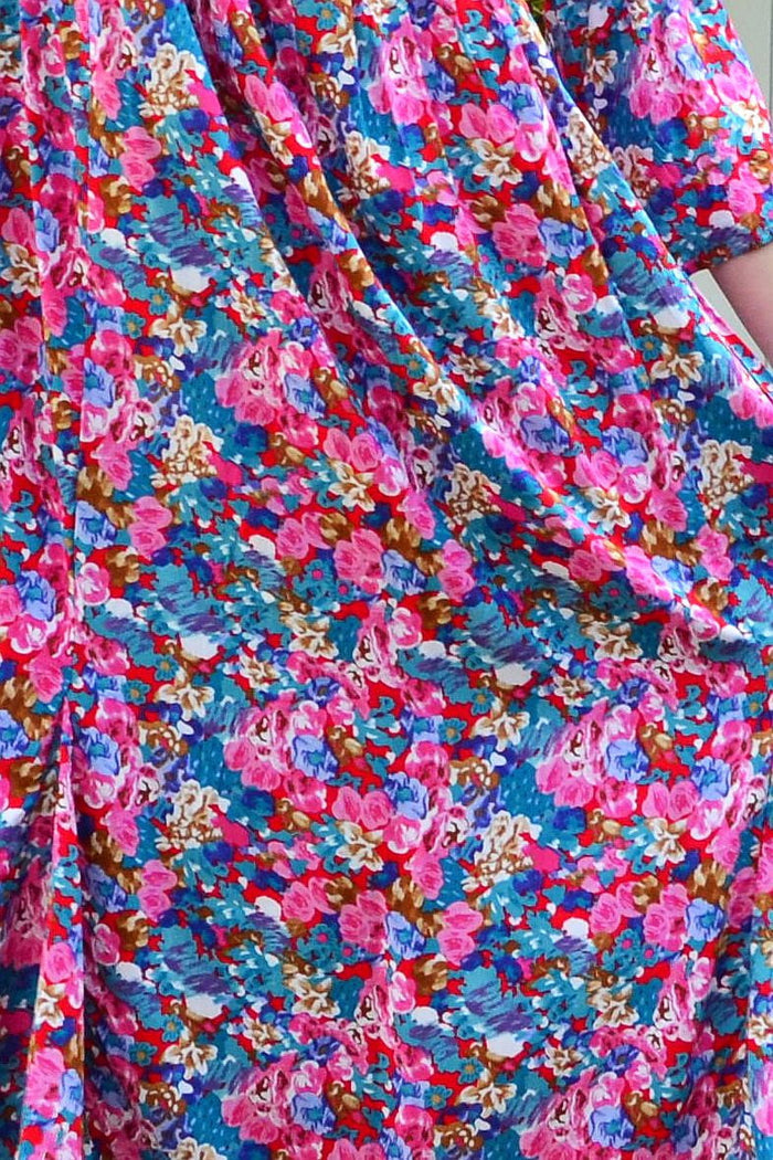 Colorful floral garden tunic dress by Hourglass featuring vibrant flower patterns and a flowing, comfortable design.