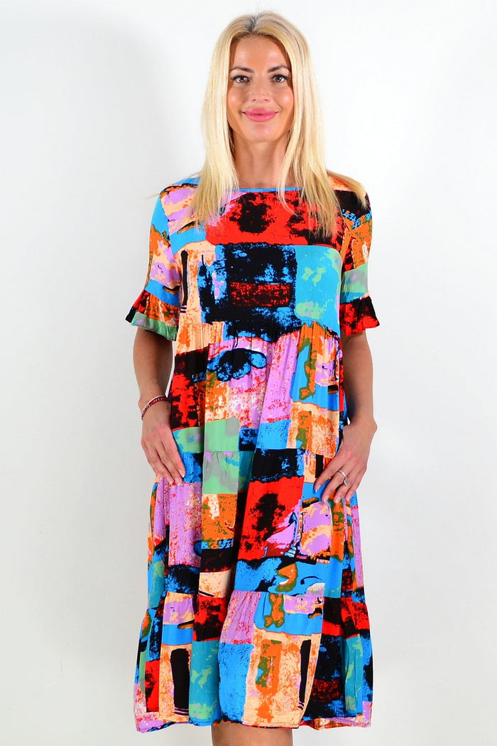 Colorful print patches on Hourglass tunic dress, vibrant design with long sleeves and a relaxed fit, perfect for casual wear.