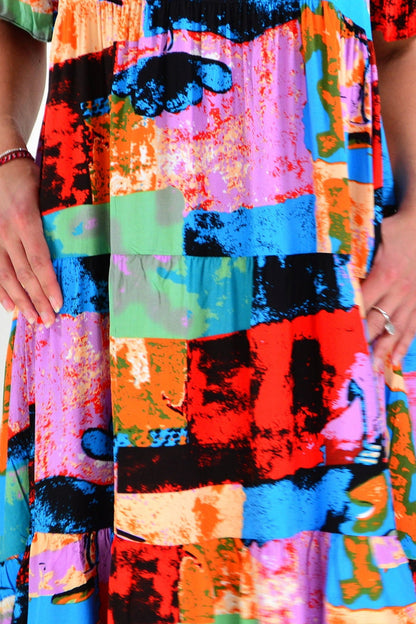 Colorful print patches on Hourglass tunic dress, showing vibrant patchwork design and relaxed fit, front view.