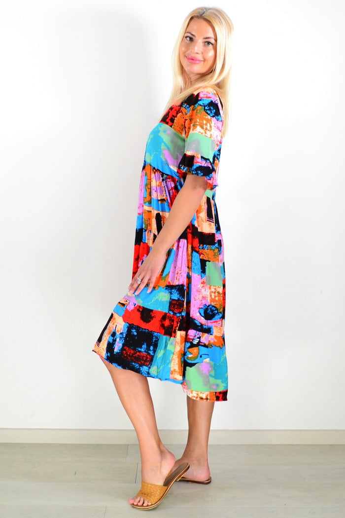 Brightly colored print patches on Hourglass tunic dress with long sleeves and a relaxed fit, displayed hanging on a plain background.