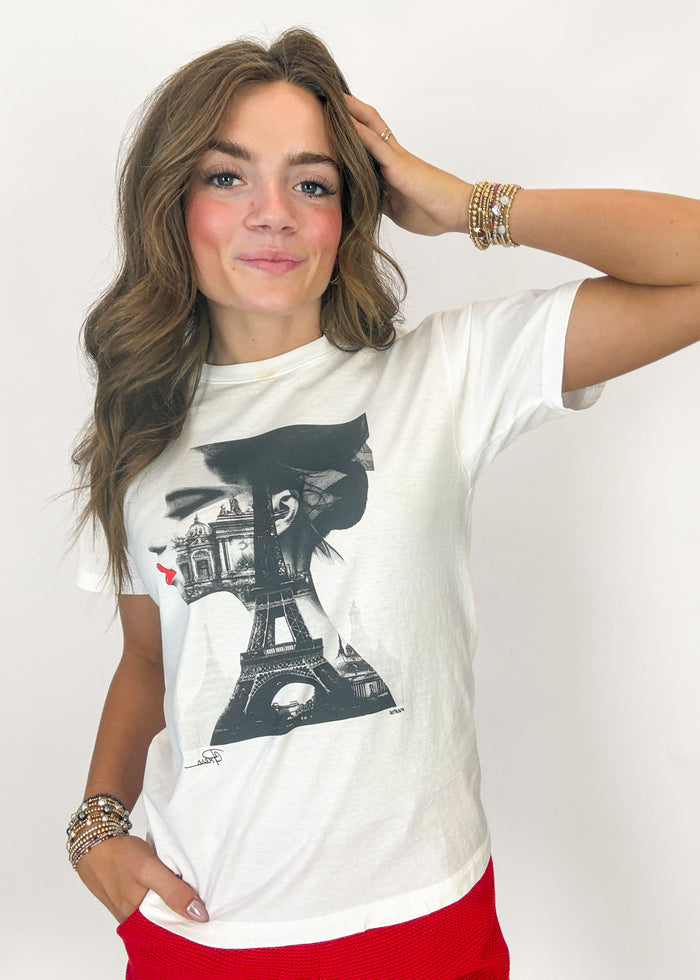 Woman wearing a white t-shirt with a graphic design on a plain background