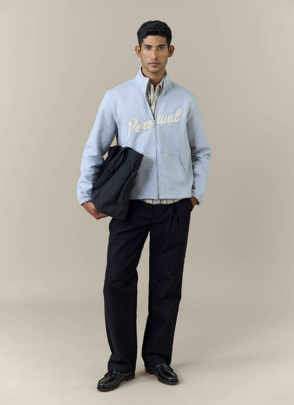 Full-length shot of a model wearing the Percival Curtis Boxy Zip Funnel Neck Sweatshirt in athletic grey with black trousers.