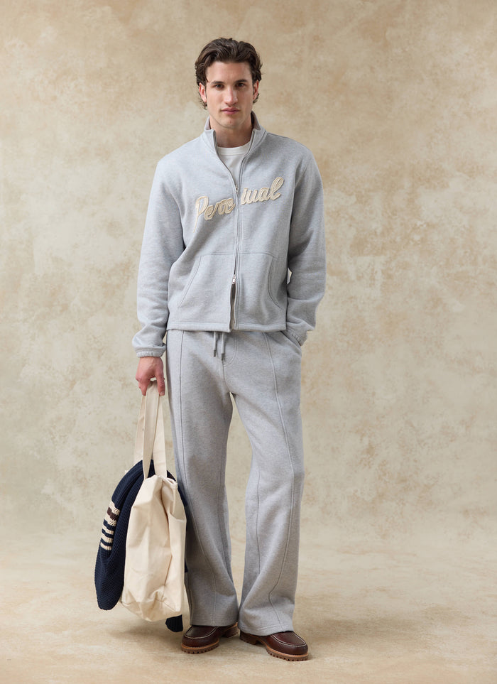 Model wears the athletic grey Percival Curtis funnel neck zip sweatshirt and matching Chronicle trackpants in cotton.