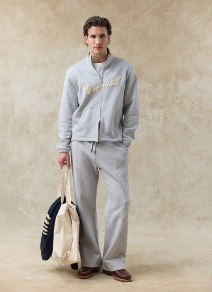 Model wears the athletic grey Percival Curtis funnel neck zip sweatshirt and matching Chronicle trackpants in cotton.